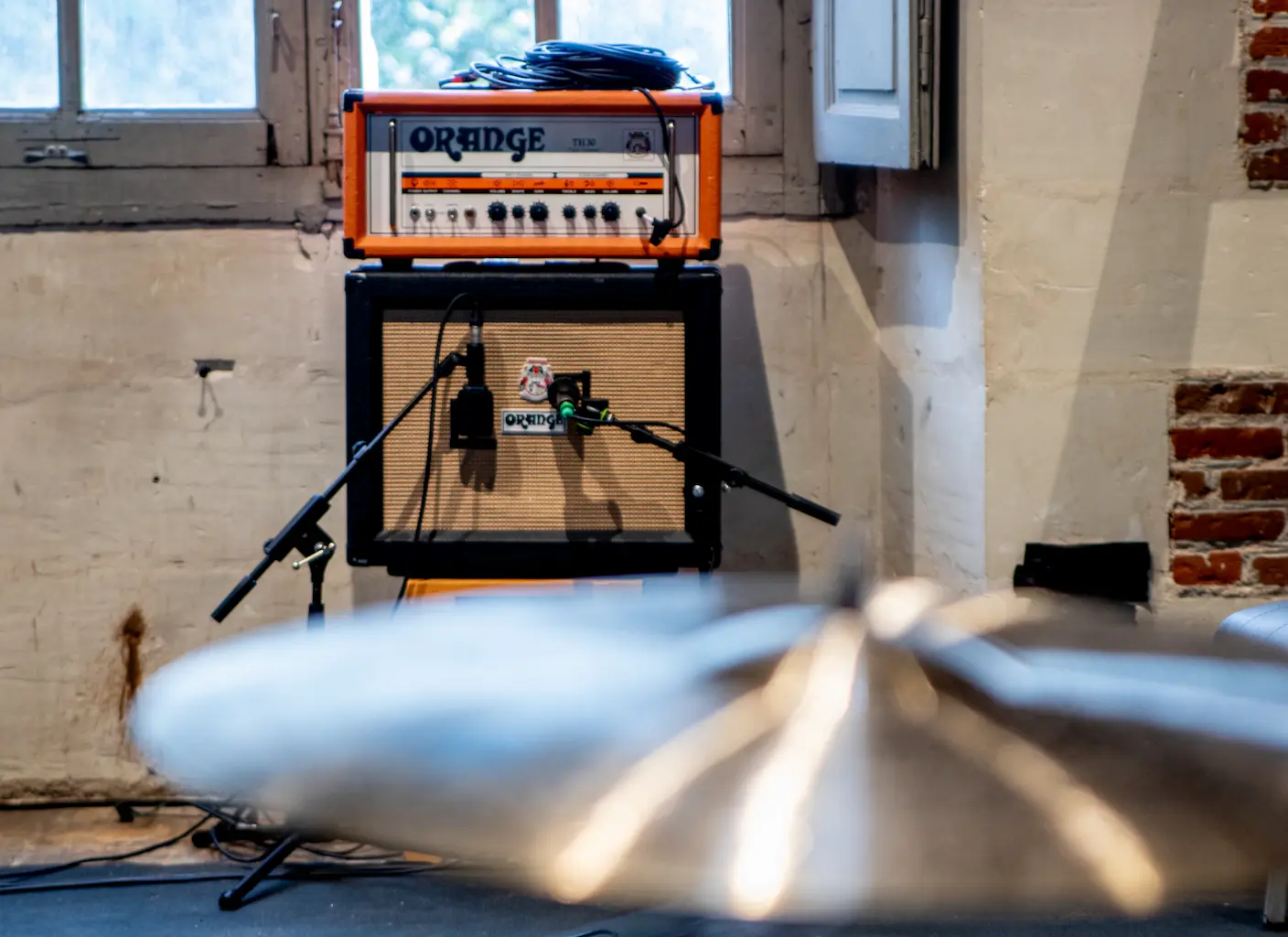 Prise de son d'un groupe de musique avec EMHR Studio. Micros placés sur un ampli guitare. Batterie au premier plan.